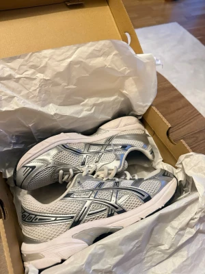 Asics Gel-1130 - Säljer mina Asics Gel-1130 i färgen White/Pure Silver, storlek 41,5. Skorna är använda men fortfarande i bra skick (8/10). De är väl omhändertagna och har normala tecken på användning. Skorna är dessutom noggrant rengjorda med professionell skorengöring. Kvitto finns. Hör gärna av dig om du har några frågor eller är intresserad!