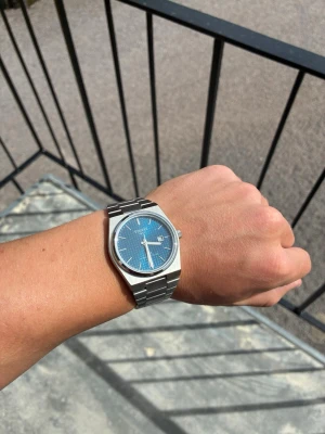 Tissot PRX blå urtavla stållänk - Snygg Tissot PRX klocka med blå urtavla och datumvisning. Klockan har en stilren, borstad stållänk och klassisk rund boett i silverfärg. Perfekt accessoar för dig som gillar tidlös design och kvalitetskänsla! Ej äkta