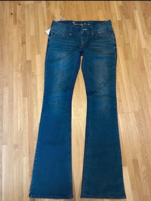 Bondelid Jeans  - Snygga blå bootcut jeans från Bondelid med klassisk femficksdesign och subtila slitningar. Jeansen har hög midja och ett litet RL-emblem på bakfickan. Perfekta för dig som gillar en tidlös och avslappnad stil. Helt nya❤️passar både Xs och S! 