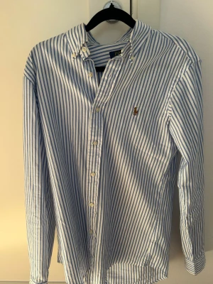 Ralph Lauren skjorta - Klassisk vit skjorta med blå ränder från Polo Ralph Lauren. Använd 1-2 gånger ny köpt annars bara varit i skåpet. Skriv vid funderingar         priset ej huget i sten vid snabb affär! 