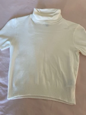 Vit polotopp med kort ärm💓 - vit polotopp med korta ärmar och ribbade kanter. Den är ganska kort skulle jag säga, från hm i storlek xs