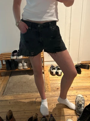 Svarta jeansshorts - Svarta jeansshorts. Shortsen har knapp- och dragkedjestängning samt en avslappnad passform. Perfekta för en avslappnad stil under varma dagar.