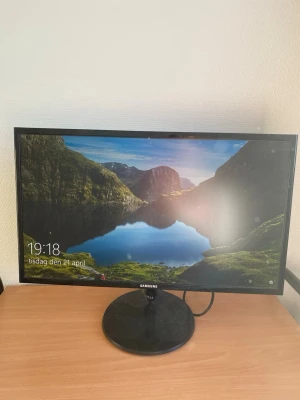 Svart stationär dator med Samsung-skärm - Säljer en svart stationär dator med stilrent chassi och en Samsung-skärm. Datorlådan har USB-portar och ljuduttag på ovansidan. Skärmen har tunn ram och rund fot. Perfekt för gaming, studier eller arbete.