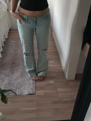 Ljusblå slitna raka jeans - Säljer ett par ljusblå jeans med raka ben och  slitningar på båda knäna. Fråga ifall du undrar något💕