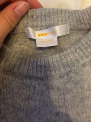 Grå stickad tröja från Gina Tricot - Mysig grå stickad tröja från Gina Tricot med rund halsringning och korta ärmar. Perfekt för lager-på-lager och enkel att matcha med andra plagg. Klassisk och stilren design som passar till många tillfällen.