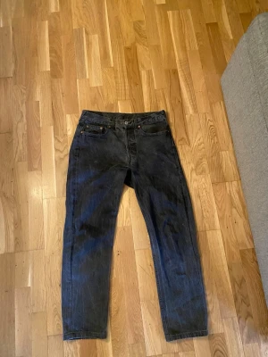 Mörkgråa Levi’s 501 - Säljer ett par mörkgråa Levi’s 501. Väldigt fräscha och snygga! Lappen är avdragen där bak men passar mig som är 176 och 67kg väldigt bra. Gissar typ 30/32. Nypris 1150kr.