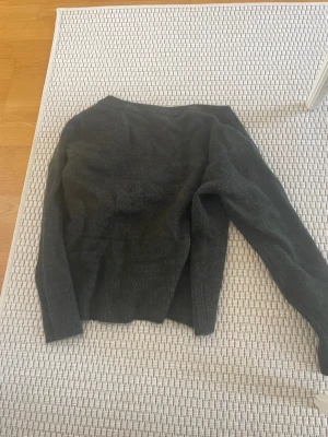 Mörkgrön stickad tröja Gina Tricot - Mysig mörkgrön stickad tröja från Gina Tricot. Tröjan har lång ärm och klassisk rund halsringning. Perfekt för lager-på-lager och passar till det mesta. Stickad i mjukt material som håller dig varm under kyliga dagar.