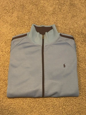 Ljusblå zip-hoodie från Polo Ralph Lauren - Blå fleece från Ralph lauren sport, XXL, bra skick, liten defekt på ena armen (se bild)