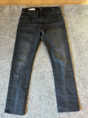 Svarta slim fit jeans från Replay - Snygga svarta slim fit jeans från Replay med klassisk femficksdesign. Jeansen har en lätt tvättad look och är tillverkade i ekologisk bomull. Perfekta för en trendig och avslappnad stil.