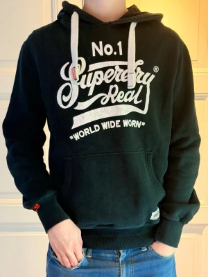 Superdry hoodie - Fint fint skick inga defekter. Vid frågor eller så är det bara att höra av er.Moddelen är 185 och väger 75