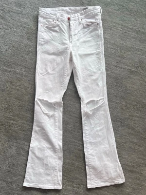 Vita jeans H&M - Vita bootcut jeans med egengjorda hål. Bronsknappar och dragkedja. Storlek 27/32, passar mig som är 1,70 m lång och vanligtvis bär storlek 38 eller 36. Endast använda ett fåtal gånger, nästan i ett nytt skick.