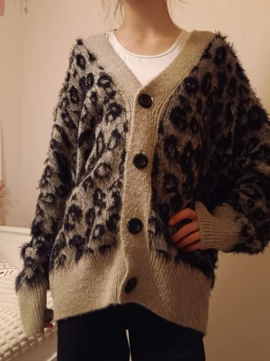 Beige leopardmönstrad kofta KappAhl - Säljer en beige kofta från KappAhl i storlek L med svart leopardmönster. Den är mycket för stor för mig,så därför ser den väldigt oversized ut. Koftan är stickad, har stora svarta knappar framtill och långa ärmar. Den har en mjuk och fluffig känsla och passar perfekt för dig som gillar leopardmönster! Den sticks inte, utan är super mysig och len. 100 kr+ frakt!!💰🐆❤️ ( skulle bli inlämnad till en secondhand och stod därför att den var såld- men ger den en chans till här på plick)