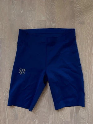 Blåa cykelshorts från Loewe - Snygga blåa cykelshorts från Loewe med logga på benet. De har en tight passform och är tillverkade i ett stretchigt syntetmaterial som passar perfekt för träning eller en aktiv vardag.