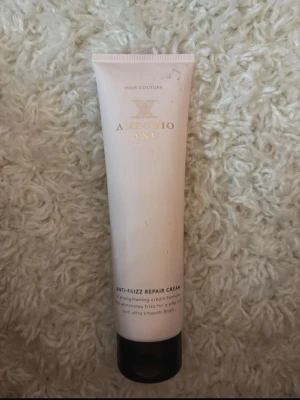 Antonio Axu Anti-Frizz Repair Cream - Anti-Frizz Repair Cream från Antonio Axu är en leave-in kräm som motverkar friss och ger ett silkeslent, slätt resultat. Kommer i en ljusbeige tub med svart lock och guldtext. Passar alla hårtyper och innehåller vårdande ingredienser som silkesaminosyror och abyssinianolja. Den är köpt från Lyko och är i 150ml💞