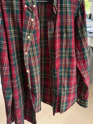 Rutig skjorta från Gant i bomull - Klassisk röd, grön och gulrutig skjorta från Gant i mjuk bomull. Skjortan har lång ärm, knappar framtill och en bröstficka. Perfekt för dig som gillar en tidlös och avslappnad stil.