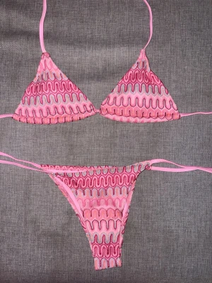 Missoni inspirerad bikini rosa - Trendig trekantsbikini i rosa och ljuslila med vågigt mönster och knytband. Bikinin har en ungdomlig vibe och passar perfekt för strandhäng. Materialet känns mjukt och stretchigt, och toppen har klassisk trekantsform med justerbara band. ENBART TESTAD. Storlek S- passar xs- s. Man får med sån tillhörande kjol som på bilden