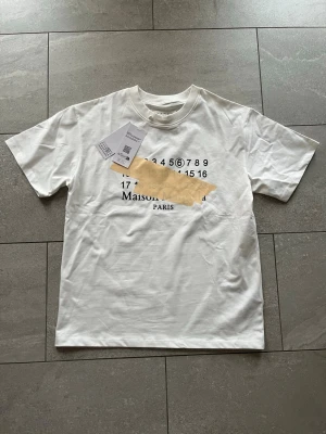Vit Maison Margiela t-shirt - En vit maison margiela t shirt i storlek S men sitter som en M. Passar dig mellan 190-180. Lapparna kvar och qr koden fungerar. Fri frakt!