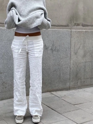 Vita linnebyxor med vida ben - Säljer de klassiska vita linnebyxorna från Lova Widerbergs märke Alobha Label i modellen ”Everyday linen pants” 🤍  Storlek M. Avslappnad passform ✨  Materialet är 100% linne med tunn bomullsfodring, så de är inte genomskinliga 🙌  Säljer då de kan komma till bättre användning hos någon annan.   Byxorna är i fint skick och har bevarats väl! Dock har de blivit lite slitna i byxkanten samt har några sma hål i grenen, men detta är inget som syns när man har byxorna på sig! (Se sista bilderna)