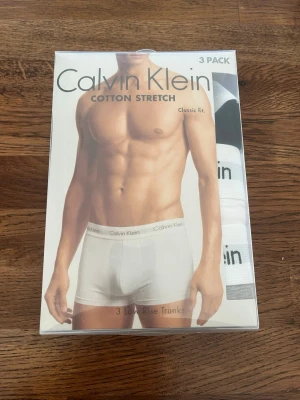 Vita kalsonger Calvin Klein 3-pack - Obs säljer då de blev fel beställning till min kille, därav endast öppnade💕 Säljer ett 3-pack vita kalsonger från Calvin Klein i modellen Low Rise Trunks. Tillverkade i mjuk bomull med stretch för skön passform och klassisk midjeresår med logga. Perfekta för dig som gillar stilrena och bekväma underkläder.