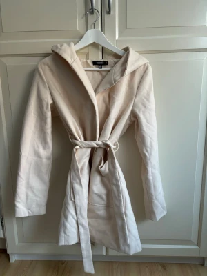Ny kappa - Superfin kappa med knytband i midjan, fickor framtill och luva Aldrig använd, i nyskick
