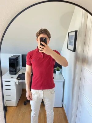 Röd pikétröja från Ralph Lauren - Klassisk röd pikétröja från Ralph Lauren med blå logga broderad på bröstet. Den är tillverkad i 100% bomull. Hör gärna av dig vid frågor!