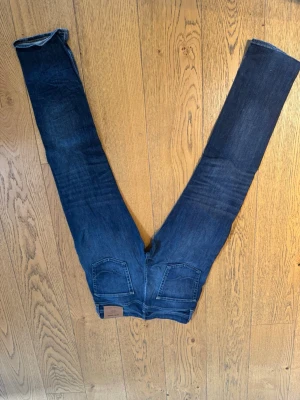 Mörkblå raka jeans - Snygga mörkblå jeans med raka ben och klassisk femficksdesign. Jeansen har en läderpatch bak i midjan och är tillverkade i slitstark denim. Perfekta för en avslappnad och trendig stil. De är W31 34L men passar som 32L