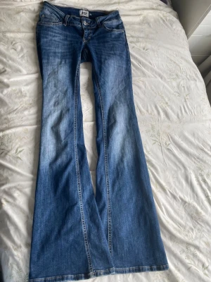 Low waist blaze jeans - tall - Säljer ett par låg midjade jeans från 157 med snygg tvätt och klassiska detaljer. Jeansen har låg midja, utsvängda ben. Perfekta för dig som vill ha ett par riktigt schyssta jeans i garderoben .     Defekter : Ett litet hål längst nere vid jeansen. 💕