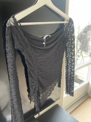 Svart spetsblus - Säljer en svart långärmad topp i spets, köpte på newyorker. Inte alls använd 