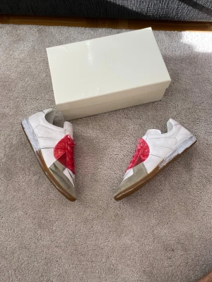 Maison Margiela Japan 2006 Gats - En av de första Maison Margiela Gatsen som kom ut, köp dessa sjukt snygga och exklusiva gatsen och var säker på att ingen har något liknande. Skorna har röda skosnören och klassisk gummisula. Perfekt för dig som gillar statement-plagg och vill sticka ut.