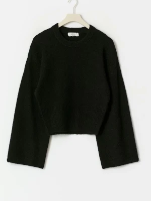 Svart croppad stickad tröja - Trendig svart stickad tröja med croppad passform och vida ärmar. Rund halsringning och mjukt material som ger en avslappnad look. Perfekt att matcha med höga jeans eller kjol.