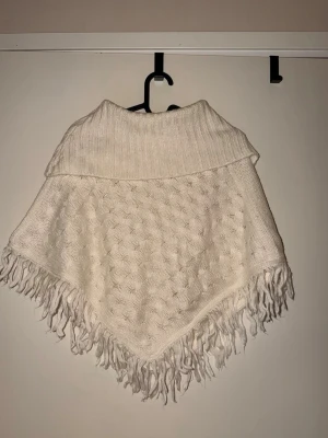 Vit stickad sjal med fransar - Mysig vit stickad sjal med bred krage och dekorativt mönster.