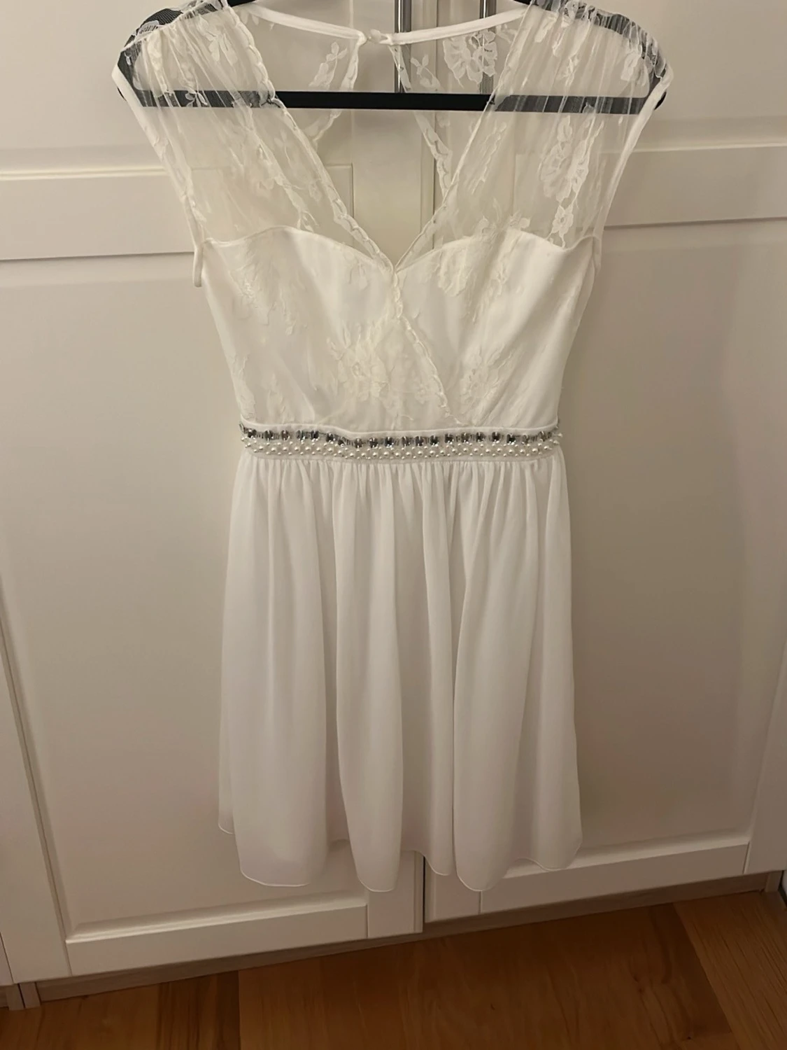 Vit spetsklänning med pärldetaljer