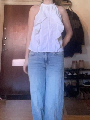 Ljusblå raka jeans i bomullsdenim - Säljer ett par ljusblå jeans med rak passform och låg midja. Jeansen har klassisk femficksdesign och stängs med dragkedja och knapp. Perfekta för en avslappnad och trendig look. Materialet är denim i bomull.