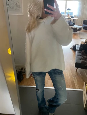 Blå slitna low waist jeans - Säljer ett par blå low waist jeans med slitningar och hål på benen. Jeansen har en avslappnad passform och klassisk femficksdesign. Perfekta för en cool och avslappnad stil. Materialet är denim i bomull. Köpt i Köpenhamn second hand 