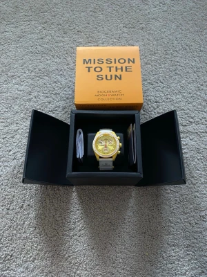 Omega x Swatch Mission to the Sun - Säljer en Omega x Swatch MoonSwatch Mission to the Sun med gul boett och matchande gul urtavla. Klockan har vita detaljer och vit rem med Omega-logga. Biokeramisk konstruktion och sportig design, perfekt för dig som gillar unika accessoarer.