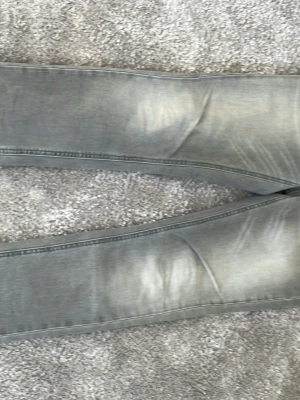 Nudie jeans Lean Dean - Snygga grå slim fit jeans med slitningar och tvättade detaljer längs benen. Jeansen har en klassisk femficksmodell och är tillverkade i mjukt denimtyg som ger en skön passform. Perfekta för en avslappnad och trendig look. 30/32