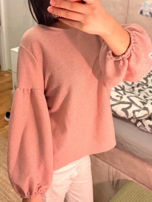 Rosa ribbad topp med ballongärmar🌸 - Supersöt ljusrosa topp med ribbad struktur och vida ballongärmar med resår vid handlederna. Avslappnad passform och rund halsringning. 