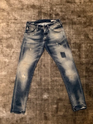 Jack and jones slim glenn  - Säljer ett par blå jeans från jack and jones med slitningar (w29 L32)och patchdetaljer på framsidan. Jeansen har en slim fit, klassiska fem fickor och ljusa tvättade partier för en trendig look. De är från italien och är i princip nya! Är öppen för prisförslag!