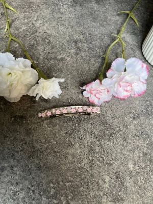 Handgjort hårspänne med blomdetaljer - Ett hårspänne med blommor och pärlor i rosa, handgjort från vårat UF företag🥰✨ Ett enkelt spänne som man kan fästa vart man vill och ha till alla tillfällen, väldigt fint och matcha nu till våren/sommaren🤗