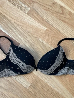 Svart push-up bh med spets och prickar - Svart intimissimi push-up bh med beige spetsdetaljer och små prickar💕Använd endast två gånger och är i väldigt bra skick!! (Inga defekter)💕💕