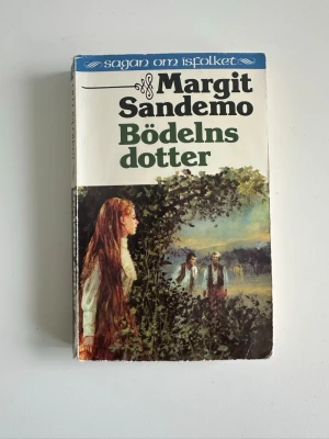 Bok ”Bödelns dotter” av Margit Sandemo - Boken ”Bödelns dotter” av Margit Sandemo, fristående del i populära kult-serien Sagan om Isfolket. En klassiker för alla som gillar fantasy, spänning och romantik.   ISBN: 91-7710-164-2