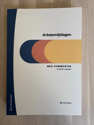 Arbetsmiljölagen med kommentar - Boken 'Arbetsmiljölagen med kommentar' av Bo Ericson är en kursbok med vit, blå, gul och orange framsida. Den är i mjukt omslag och tillhör Studentlitteraturs arbetsrättsbibliotek. Perfekt för dig som pluggar arbetsmiljörätt eller juridik.