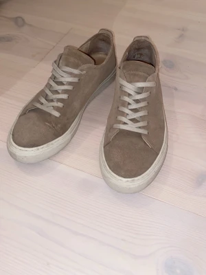 Beiga sneakers i mocca från Bianco - Ett par schyssta beiga sneakers med vit sula. Dom är rätt så använda, lite små defekter bak i sulan och moccan är inte i toppform. Inte bästa skicket, så därför säljer jag dom till någon i behov eller som vill försöka rädda upp dom.👍Priset kan självklart diskuteras, hör av er vid minsta fundering!😀 