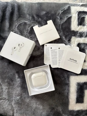 Apple AirPods 4 - Säljer ett par vita Apple AirPods med tillhörande laddningsetui och originalförpackning. Trådlösa hörlurar. Perfekta för musik, samtal och vardagsbruk. Allt originaltillbehör och manualer medföljer. Oanvända, hade köpt dem och öppet köp hade gått över. 