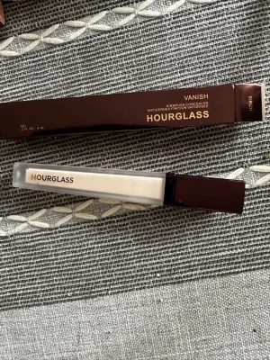 Hourglass Vanish Concealer Birch - Hourglass Vanish Airbrush Concealer i nyansen Birch. Kommer i en elegant, rektangulär tub med mörkbrunt lock och frostat glas. Concealern har en ljus, neutral ton och ger en naturlig finish. Perfekt för att täcka mörka ringar och ojämnheter.