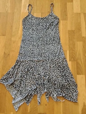 Leopardklänning  - Klänning med asymmetrisk volangkant nertill. Supertunnt material som är perfekt för varma sommardagar. Storlek M, men står ej märke.