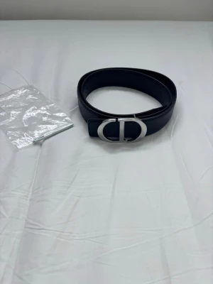 CD bälte - Snyggt bälte från CD. Jag köpte fel storlek och tänkte att någon annan blir lyckligare av den så jag säljer den nu. PS såklart är det en replika men det är nog det mesta på plick ändå