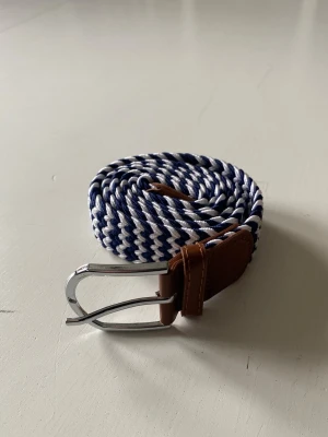 2 Flätade bälten  - Två riktigt feta flätade bälten i otroligt bra skick. Ett svart vitt o ett blå vitt. De säljs för de inte riktigt kommit till användning. De är endast använt någon enstaka gång, så de är i princip nyskick. Skriv vid frågor!