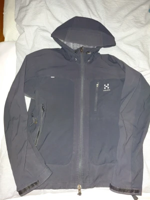 Svart vindjacka från Haglöfs - Snygg svart vindjacka köpt från Haglöfs för 2400. Tar endast kontant elr byten. Kan mötas upp varsom i sthlm. Står M men passar endast S, elr slimbody upp till 172. Kom med bud elr byten..