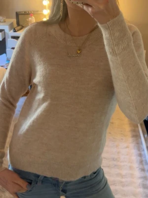 Beige stickad tröja i ullmix - Mysig beige stickad tröja med rund hals och långa ärmar.  Köpt från selected, använd en gång 